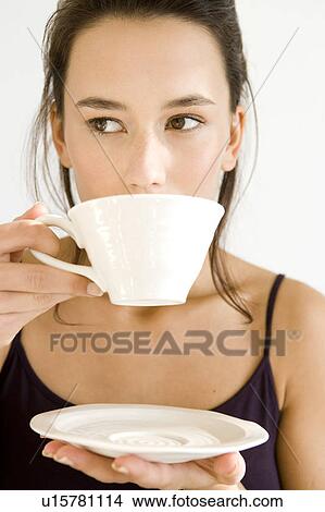 Picture - A young woman drinking from a cup. Fotosearch