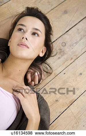 A young woman laying on the floor View Large Photo Image Stock Photo - A young woman laying on the floor. Fotosearch