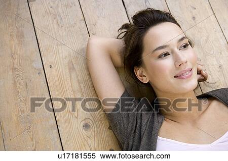 Stock Photography - A young woman laying on the floor. Fotosearch