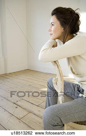 Stock Image - A young woman sitting on a chair. Fotosearch