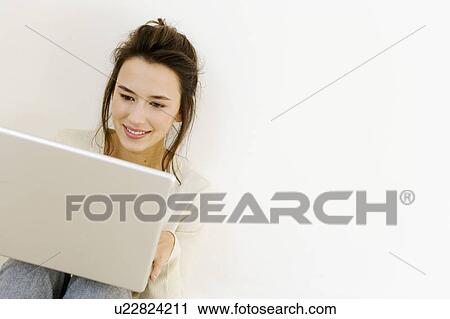 A young woman using a laptop View Large Photo Image Stock Image - A young woman using a laptop. Fotosearch
