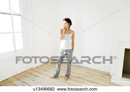 A young woman using a mobile phone View Large Photo Image Stock Image - A young woman using a mobile phone. Fotosearch
