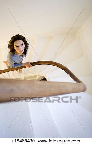 Stock Image - A young woman walking up stairs. Fotosearch