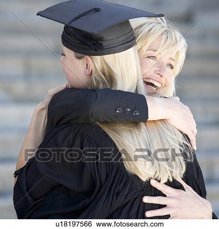 Stock Photograph - A graduate hugging her mother. Fotosearch