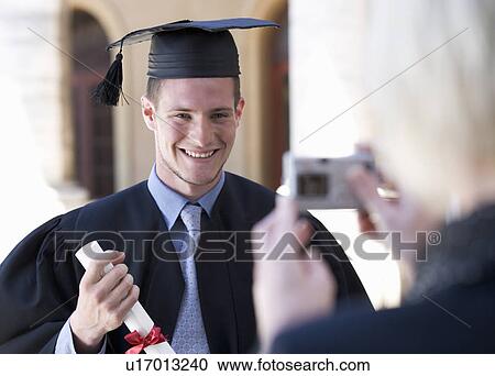 Stock Image - A graduate posing for a family photograph. Fotosearch