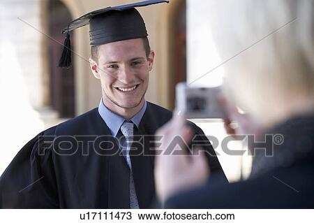 Stock Image - A graduate posing for a family photograph. Fotosearch