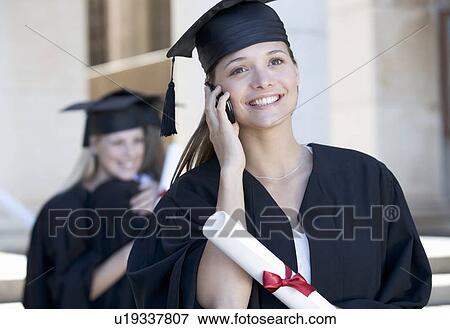 A graduate using a mobile phone View Large Photo Image Stock Photo - A graduate using a mobile phone. Fotosearch