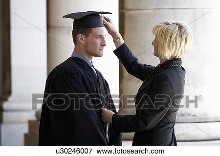 A mother checking her graduate son's gown View Large Photo Image Stock Photo - A mother checking her graduate son's gown. Fotosearch