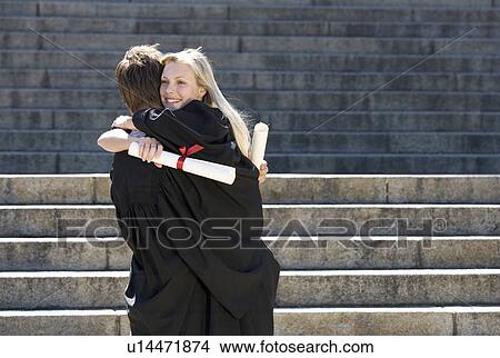 Picture - Two graduates embracing. Fotosearch
