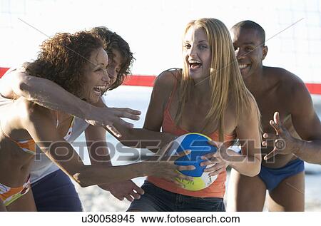 Stock Photography - A game of beach volleyball. Fotosearch