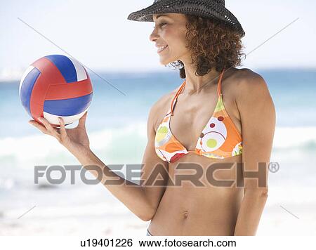Stock Photograph - A woman holding a ball. Fotosearch