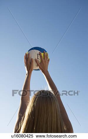 Stock Photography - A woman playing beach volleyball. Fotosearch