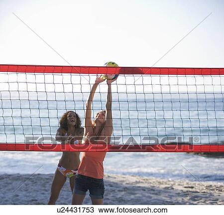 Two women playing beach volleyball View Large Photo Image Stock Image - Two women playing beach volleyball. Fotosearch