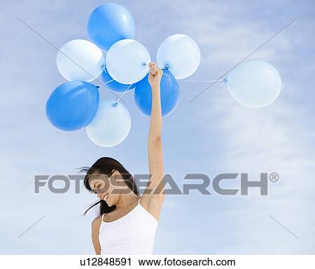 A woman holding a bunch of balloons View Large Photo Image Stock Image - A woman holding a bunch of balloons. Fotosearch