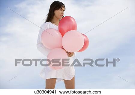 A woman holding a bunch of balloons View Large Photo Image Stock Image - A woman holding a bunch of balloons. Fotosearch