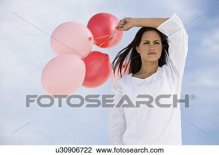 A woman holding a bunch of balloons View Large Photo Image Stock Image - A woman holding a bunch of balloons. Fotosearch