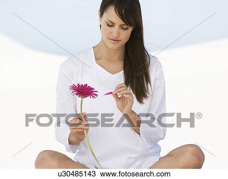 Stock Image - A woman holding a flower. Fotosearch