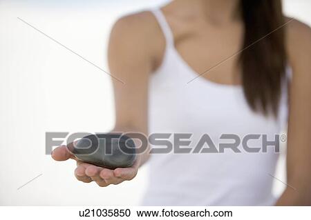 Stock Image - A woman holding a stone. Fotosearch