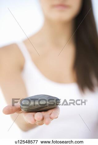 A woman holding a stone View Large Photo Image Stock Photo - A woman holding a stone. Fotosearch