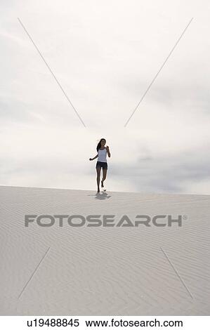Stock Photography - A young woman running in the desert. Fotosearch