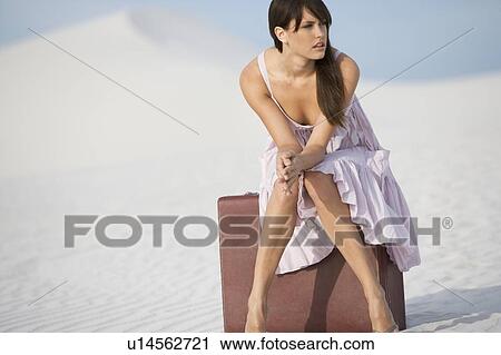 A young woman sitting on a suitcase in the desert View Large Photo Image Stock Image - A young woman sitting on a suitcase in the desert. Fotosearch