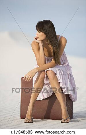 A young woman sitting on a suitcase in the desert View Large Photo Image Stock Image - A young woman sitting on a suitcase in the desert. Fotosearch