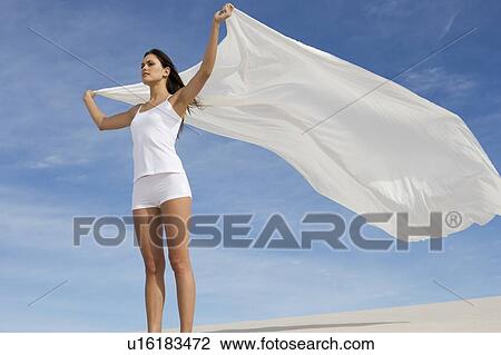 A young woman standing in the desert with a sheet View Large Photo Image Stock Image - A young woman standing in the desert with a sheet. Fotosearch