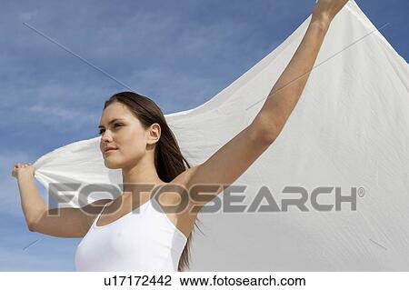 A young woman standing in the desert with a sheet View Large Photo Image Stock Image - A young woman standing in the desert with a sheet. Fotosearch
