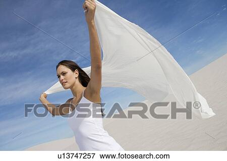 A young woman standing in the desert with a sheet View Large Photo Image Stock Photo - A young woman standing in the desert with a sheet. Fotosearch