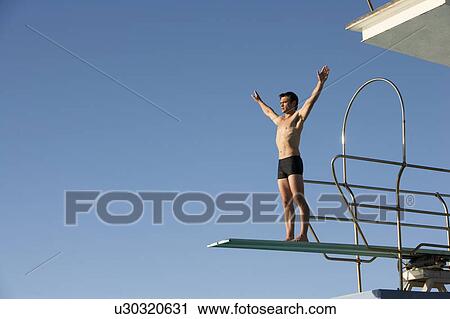 A diver standing on a diving board View Large Photo Image Stock Image - A diver standing on a diving board. Fotosearch