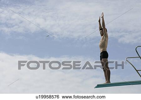 A diver standing on a diving board View Large Photo Image Stock Photograph - A diver standing on a diving board. Fotosearch