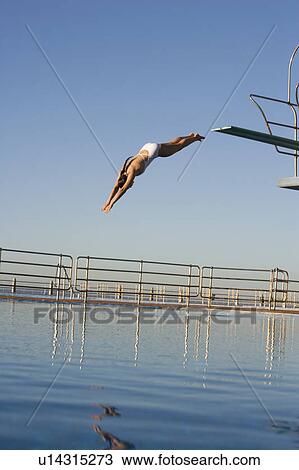 A woman diving into a pool View Large Photo Image Stock Image - A woman diving into a pool. Fotosearch