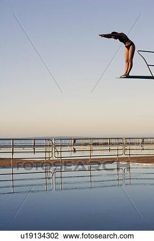 A woman diving into a pool View Large Photo Image Stock Image - A woman diving into a pool. Fotosearch
