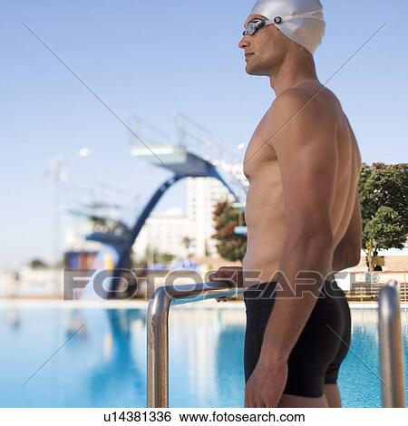 A young man standing by a swimming pool View Large Photo Image Stock Photograph - A young man standing by a swimming pool. Fotosearch