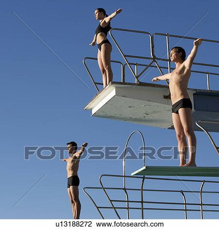 Three divers standing on diving boards View Large Photo Image Stock Image - Three divers standing on diving boards. Fotosearch
