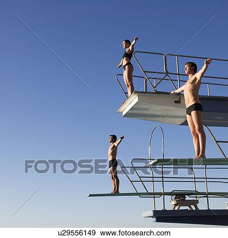 Three divers standing on diving boards View Large Photo Image Stock Photo - Three divers standing on diving boards. Fotosearch
