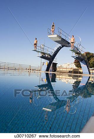 Three divers standing on diving boards View Large Photo Image Stock Photo - Three divers standing on diving boards. Fotosearch