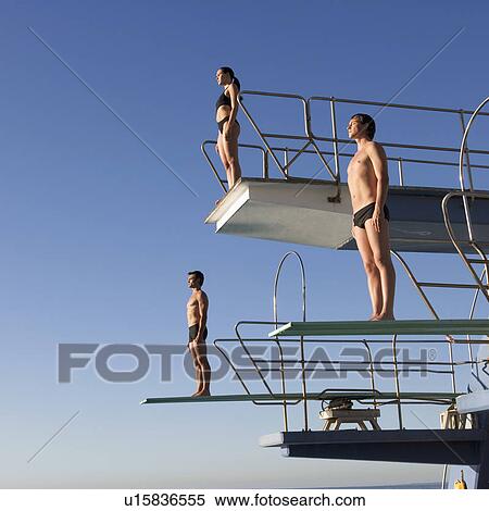 Stock Photography - Three divers standing on diving boards. Fotosearch