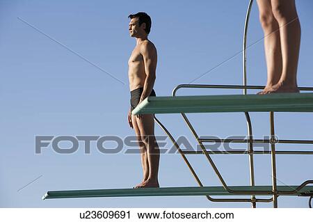 Stock Image - Two divers standing on diving boards. Fotosearch
