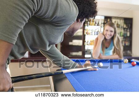 Stock Image - A teenage couple playing pool. Fotosearch