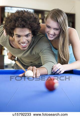 Stock Image - A teenage couple playing pool. Fotosearch