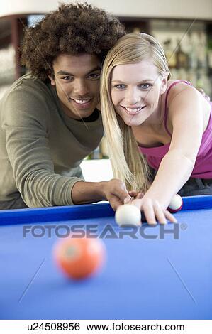 Stock Photograph - A teenage couple playing pool. Fotosearch