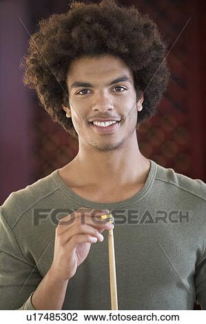 Stock Image - A young man playing pool. Fotosearch