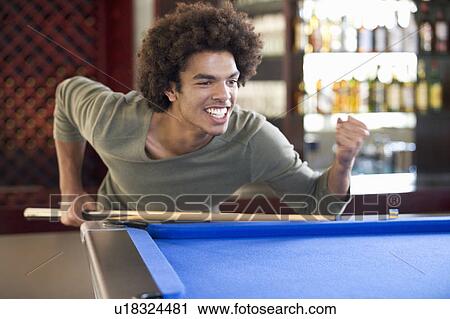 A young man playing pool View Large Photo Image Stock Image - A young man playing pool. Fotosearch