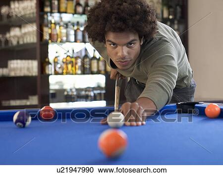 A young man playing pool View Large Photo Image Stock Image - A young man playing pool. Fotosearch