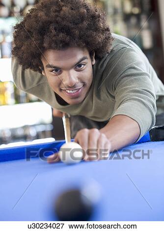 A young man playing pool View Large Photo Image Stock Photo - A young man playing pool. Fotosearch