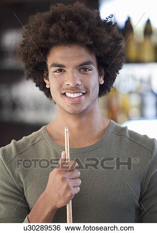 Portrait of a young man playing pool View Large Photo Image Stock Photograph - Portrait of a young man playing pool. Fotosearch