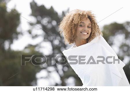 A young woman drying herself with a towel View Large Photo Image Stock Photo - A young woman drying herself with a towel. Fotosearch