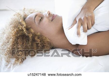 Stock Photo - A young woman laying down. Fotosearch