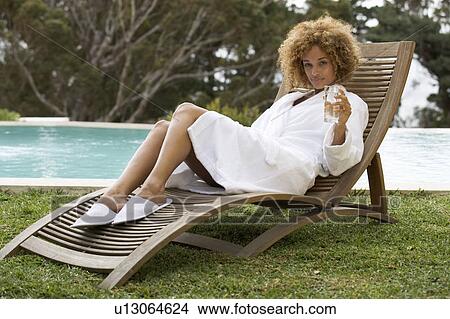 A young woman sitting on a sun lounger View Large Photo Image Picture - A young woman sitting on a sun lounger. Fotosearch